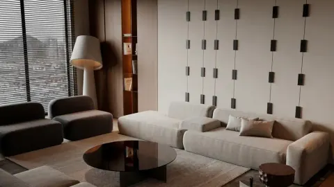 A dark luxury living room staged with a charcoal sofa and sculptural art wall