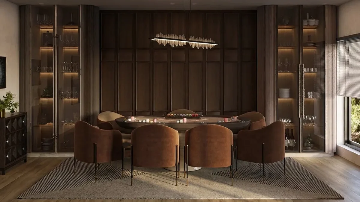 Basement game room with dark walnut paneled walls, lit glass display cabinets, an oval poker table with eight caramel leather chairs and a long linear pendant overhead