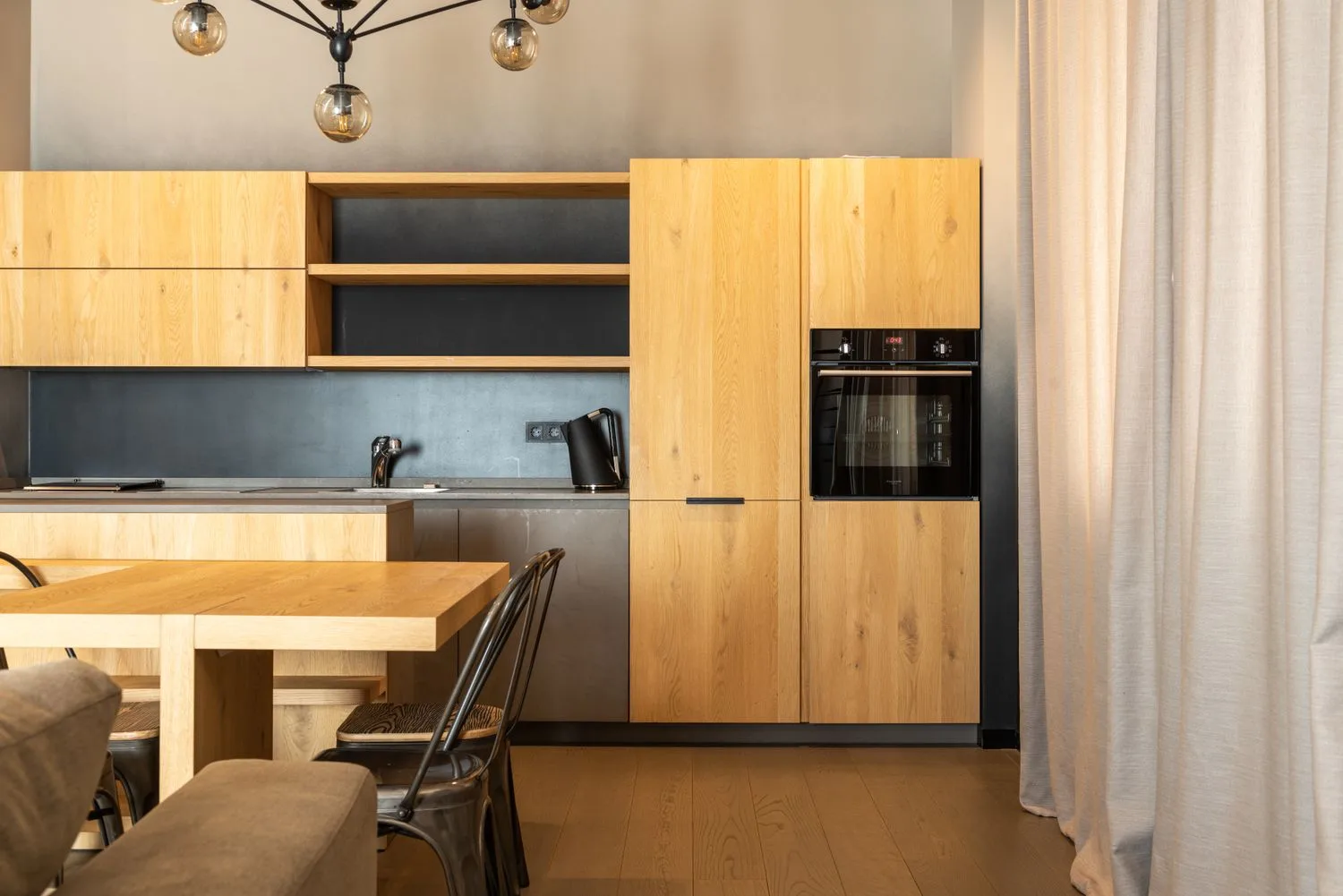 A warm modern kitchen redesign with oak cabinets, a dining area and bright natural light, the kind of result AI kitchen tools can produce