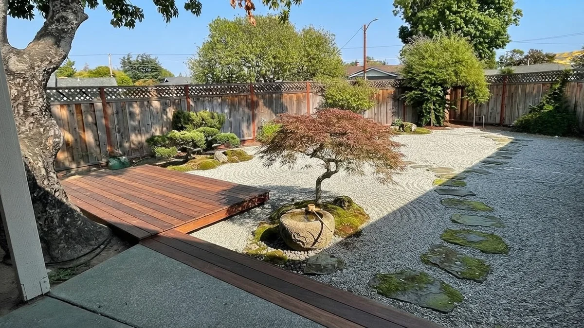 The base backyard rendered as a Japanese courtyard with raked gravel, stepping stones, a Japanese maple, clipped pines and a low deck