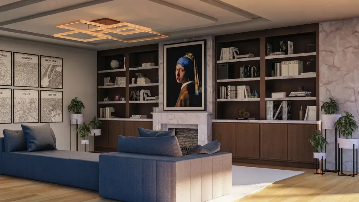 A living room with dark timber built-in bookshelves running floor to ceiling, a pale marble fireplace with a framed portrait above it, a royal blue sofa, framed city prints on the side wall and an angular gold ceiling light