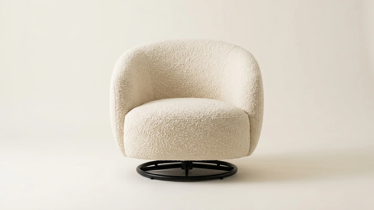 A single curved cream boucle swivel accent chair on a low black metal swivel base, a viral Wayfair-style find, shown as a clean studio product photo