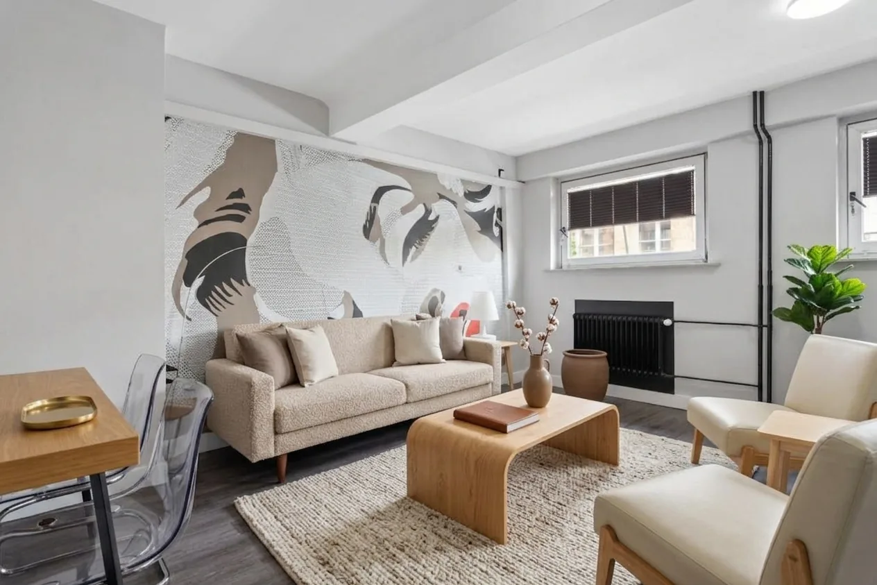 Neutral warm living room with beige sofa, cream rug, and textured natural materials — quiet luxury interior design
