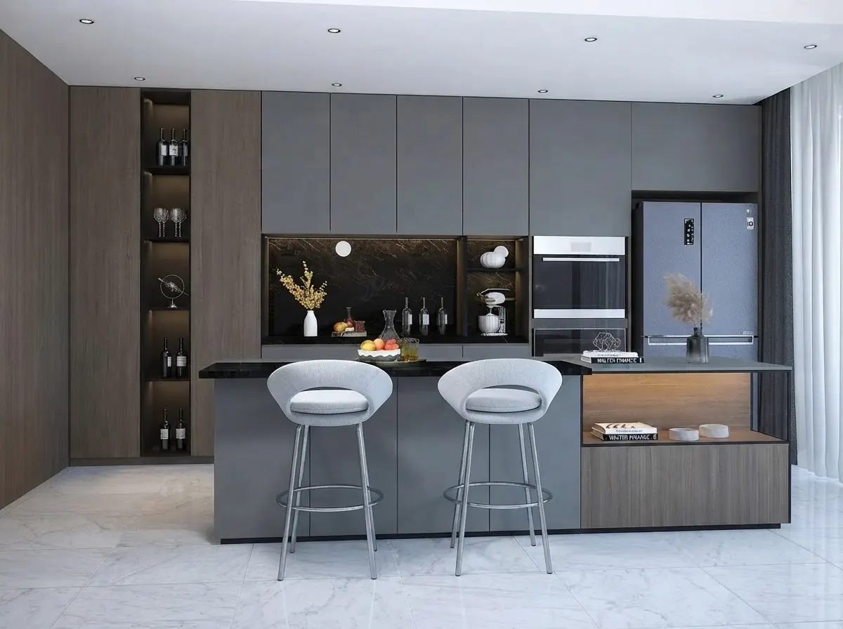 Gray kitchen island with a black top and two upholstered gray swivel counter stools with curved backs and round chrome footrings, tall gray cabinets and a wine niche behind