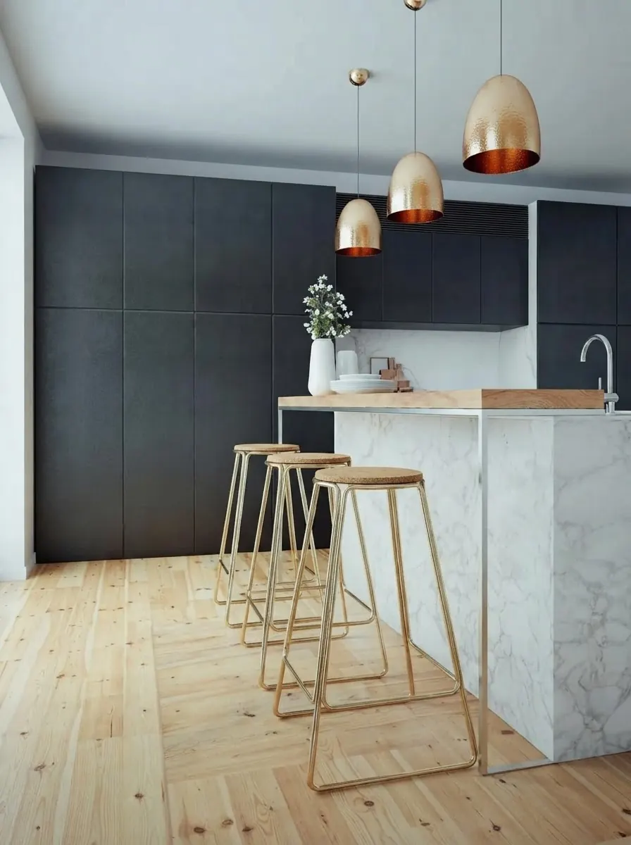 Navy kitchen with a white marble island topped by a raised pale wood ledge at bar height, three brass wire bar stools in front and copper dome pendants above