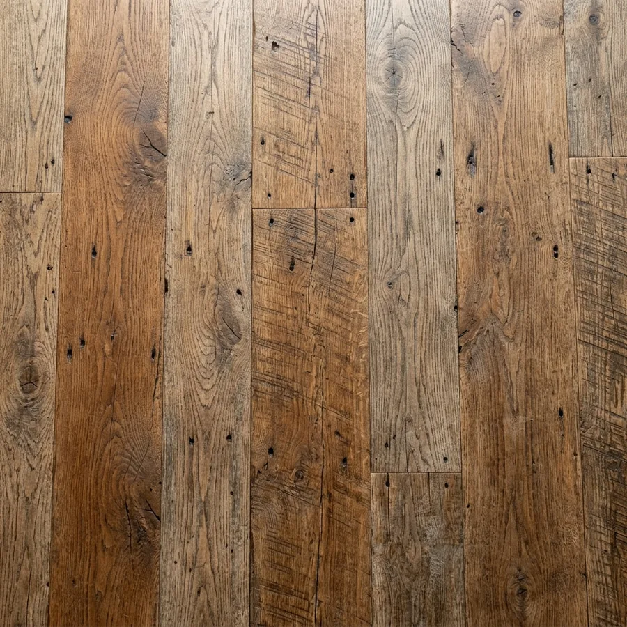 Close-up texture swatch of reclaimed barnwood plank flooring with weathered mixed brown boards and nail holes