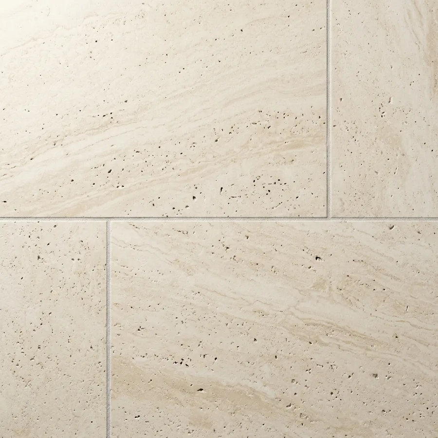 Close-up texture swatch of large-format honed travertine tile in warm ivory with natural veining
