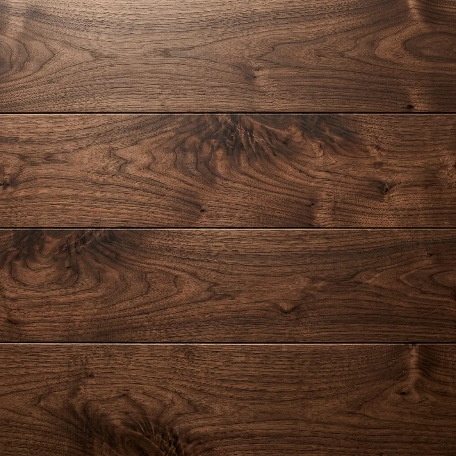 Close-up texture swatch of wide-plank American walnut flooring in deep chocolate brown with dramatic grain
