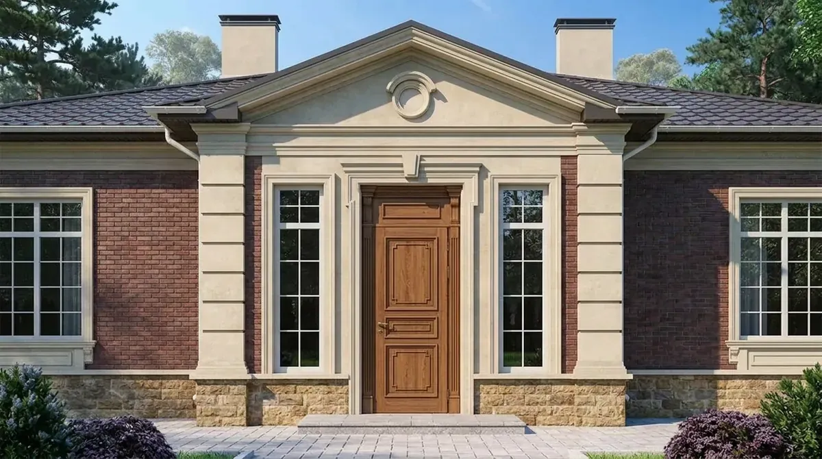 Red brick single story house with a cream stone pediment entry, tall sidelight windows and a stained wood raised panel front door