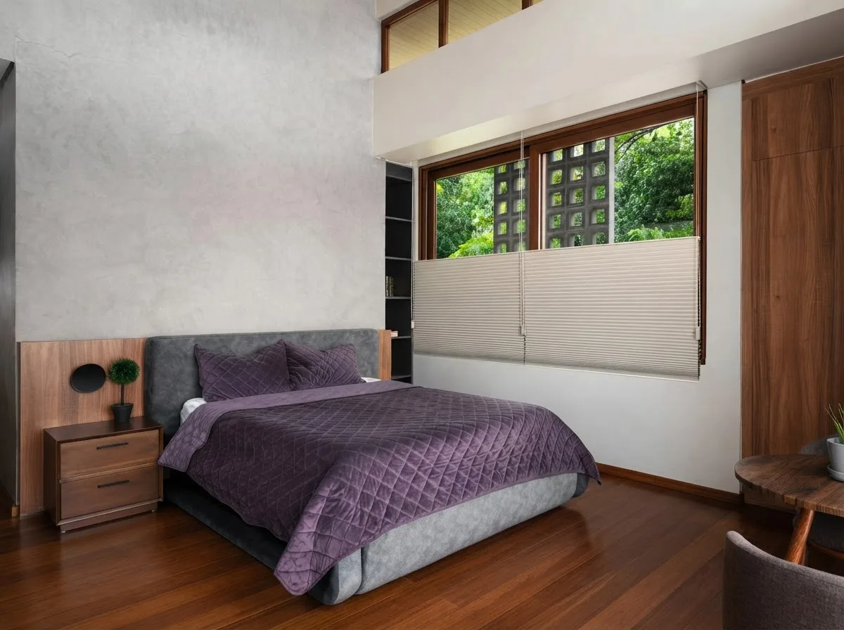 Blind lowered partway across a bedroom window, dust settling on the horizontal top edges