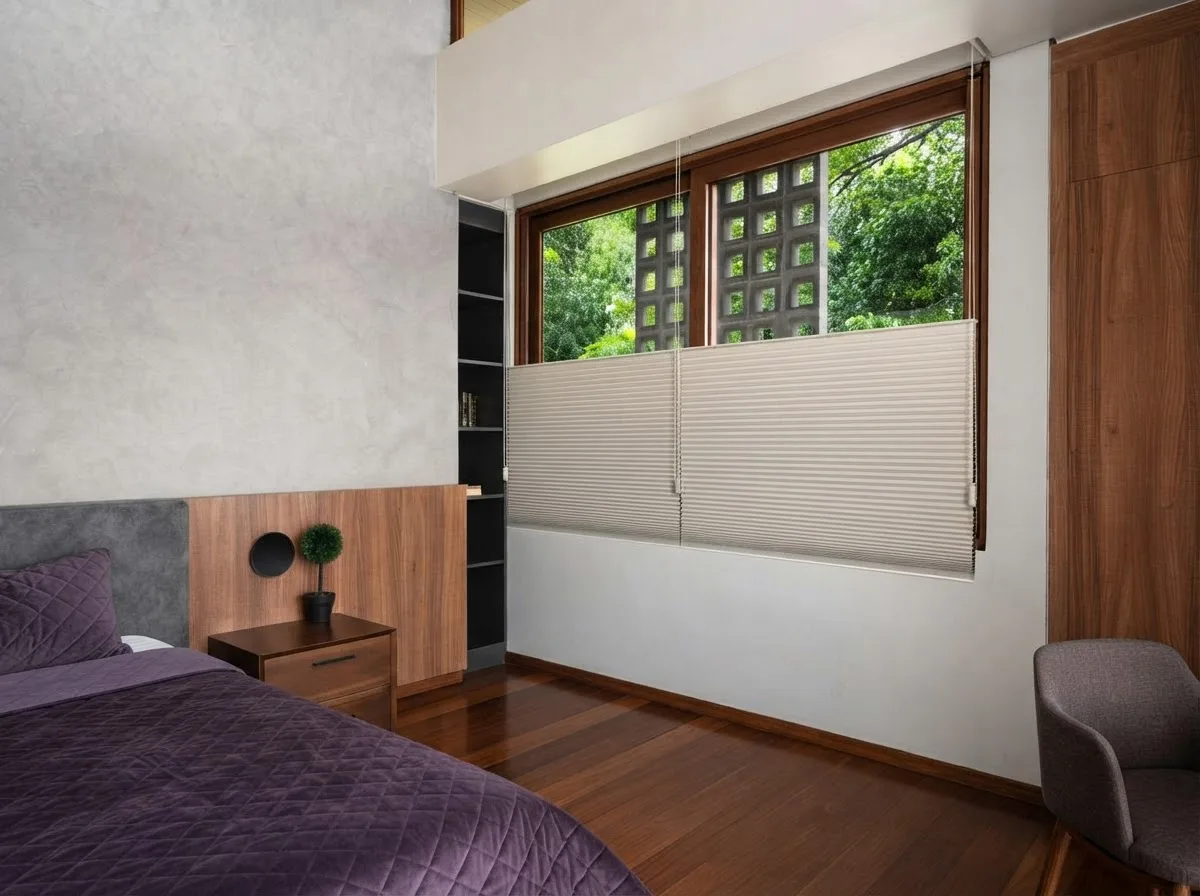 Cellular honeycomb shade half lowered over a bedroom window, the cell structure visible against the light