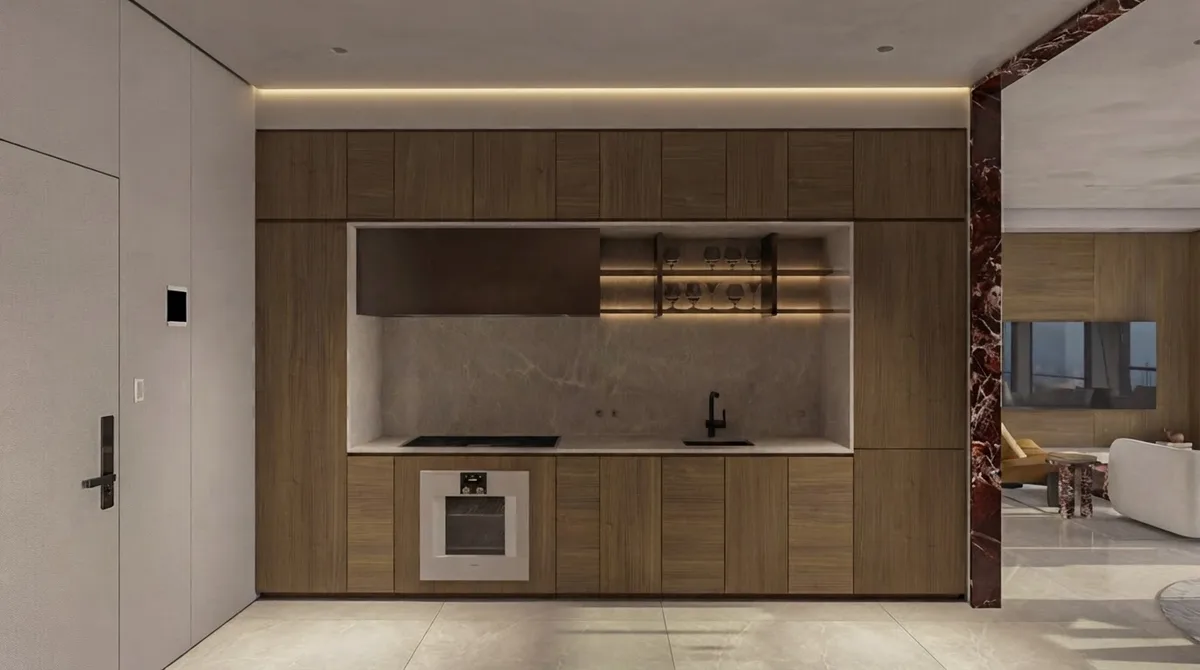 Minimal kitchenette niche with concealed appliances and a stone counter set into a flush wall of cabinetry