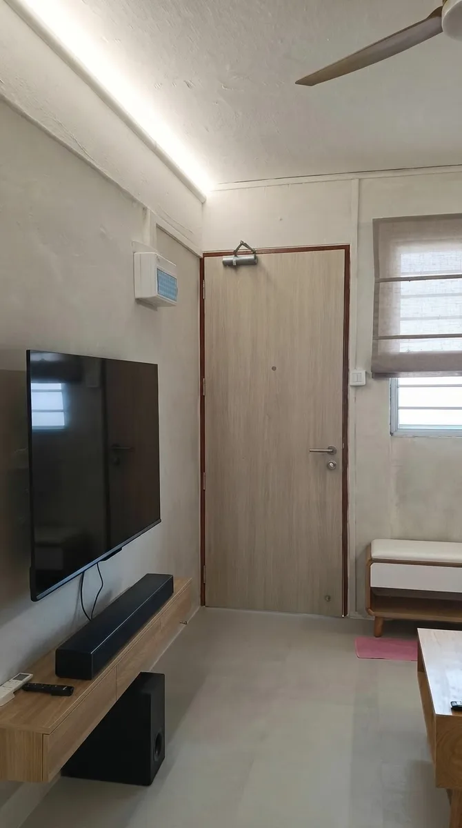 Hallway with pale stone grey limewashed walls and a wall mounted television in a real apartment