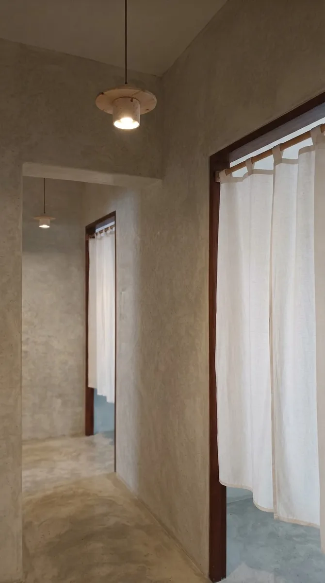 Narrow hallway with cloudy pale grey limewashed walls, a timber door and soft daylight showing the brush movement in the finish