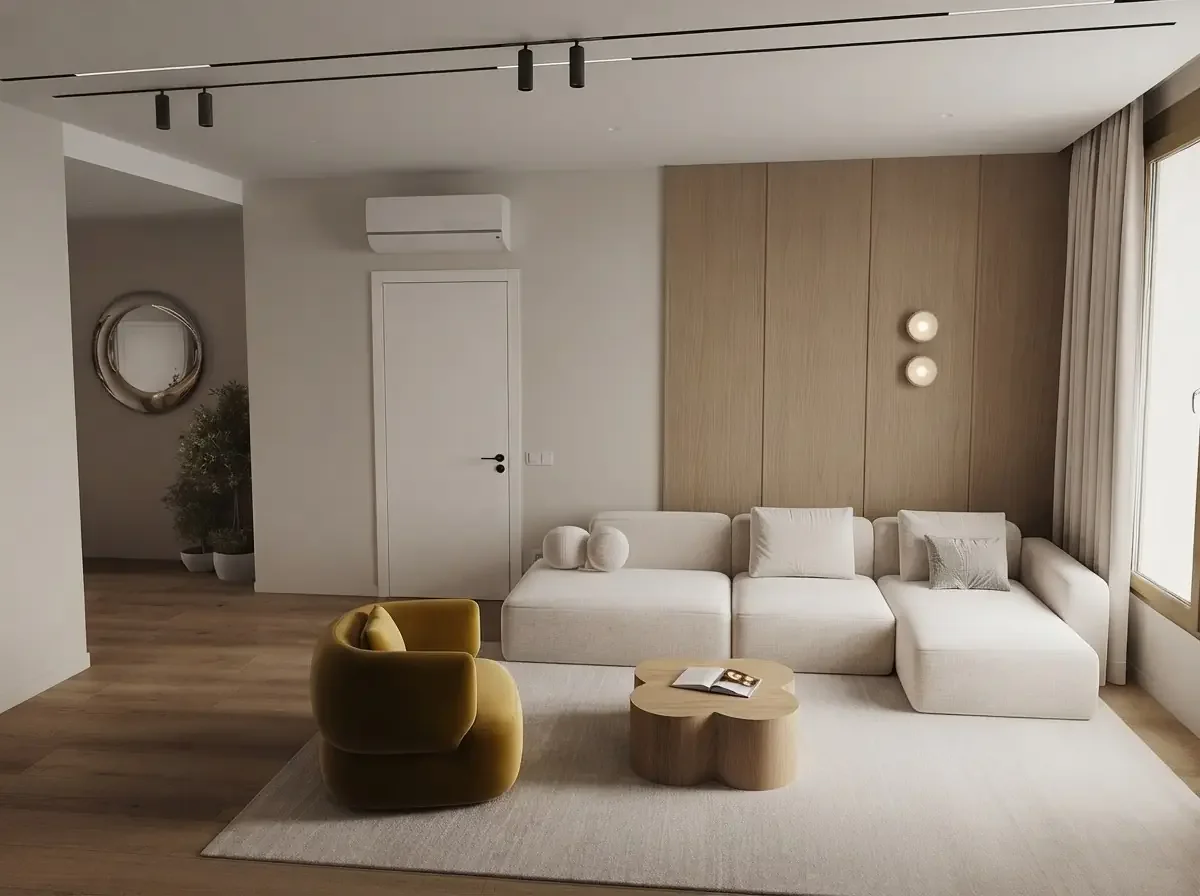 Warm minimalist apartment living room render with an L-shaped cream sofa placed across the room facing a TV wall, a walkway kept along one side and dining beyond