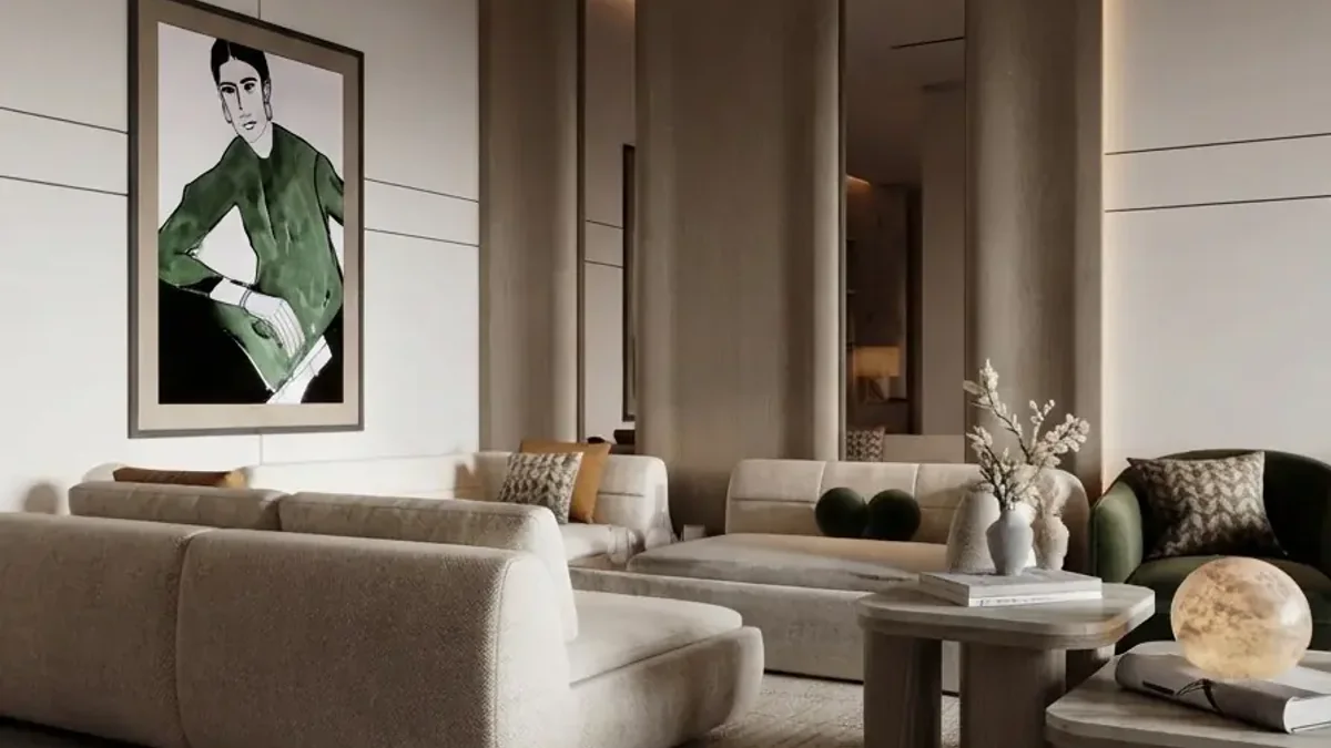 A warm beige living room with two low cream modular sofas facing each other across a small stone table, a large framed portrait in green on the wall and pale timber panelling behind