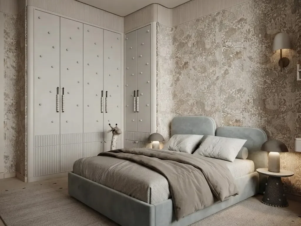 Child's bedroom with a gray blue upholstered bed, a giraffe figure beside a white padded wardrobe, a mushroom table lamp on the nightstand and textured stone look wallpaper