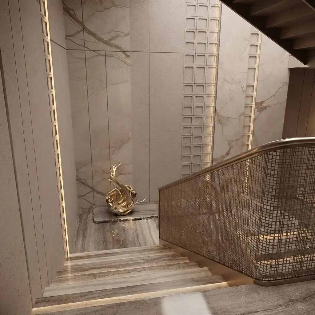 Beige travertine steps with a brass handrail and a gold sculpture at the foot of the stair