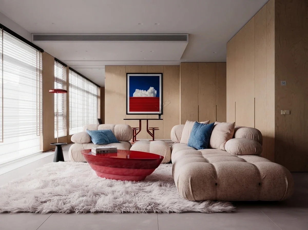 Wide view of a timber panelled living room with a single framed print above a low console on the far wall, a bouclé modular sofa and a red lacquer coffee table in the foreground