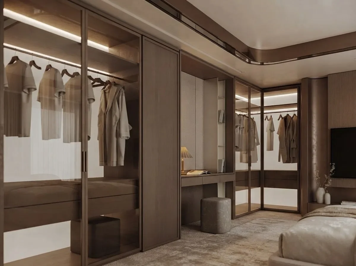 A warm oak wardrobe wall with glass doors, backlit shelves and a vanity desk in taupe tones