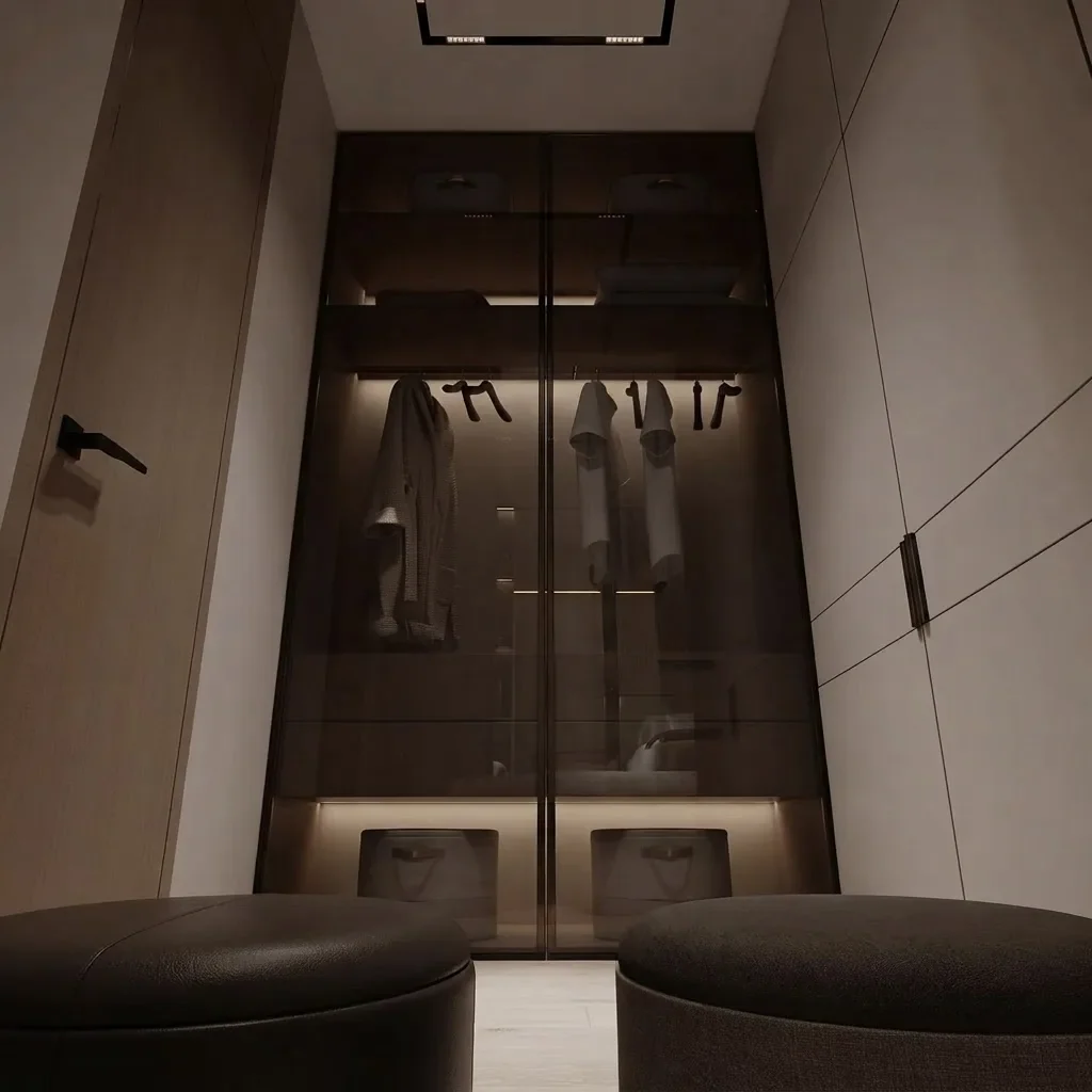 A minimal oak wardrobe niche behind smoked bronze glass with the interior shelving lit from within