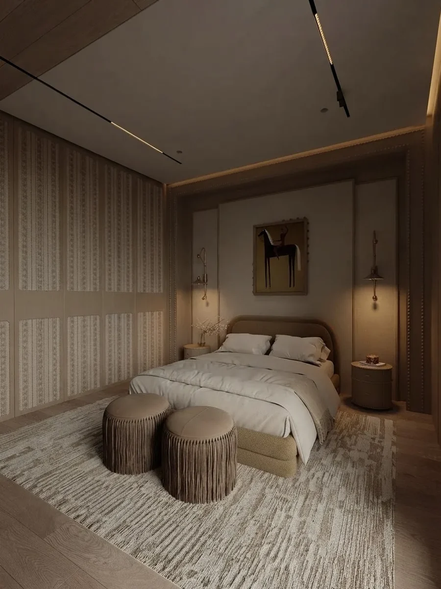 Warm cocoa bedroom with fluted wall panels, brass wall lights and one small framed horse painting centred above a curved upholstered headboard