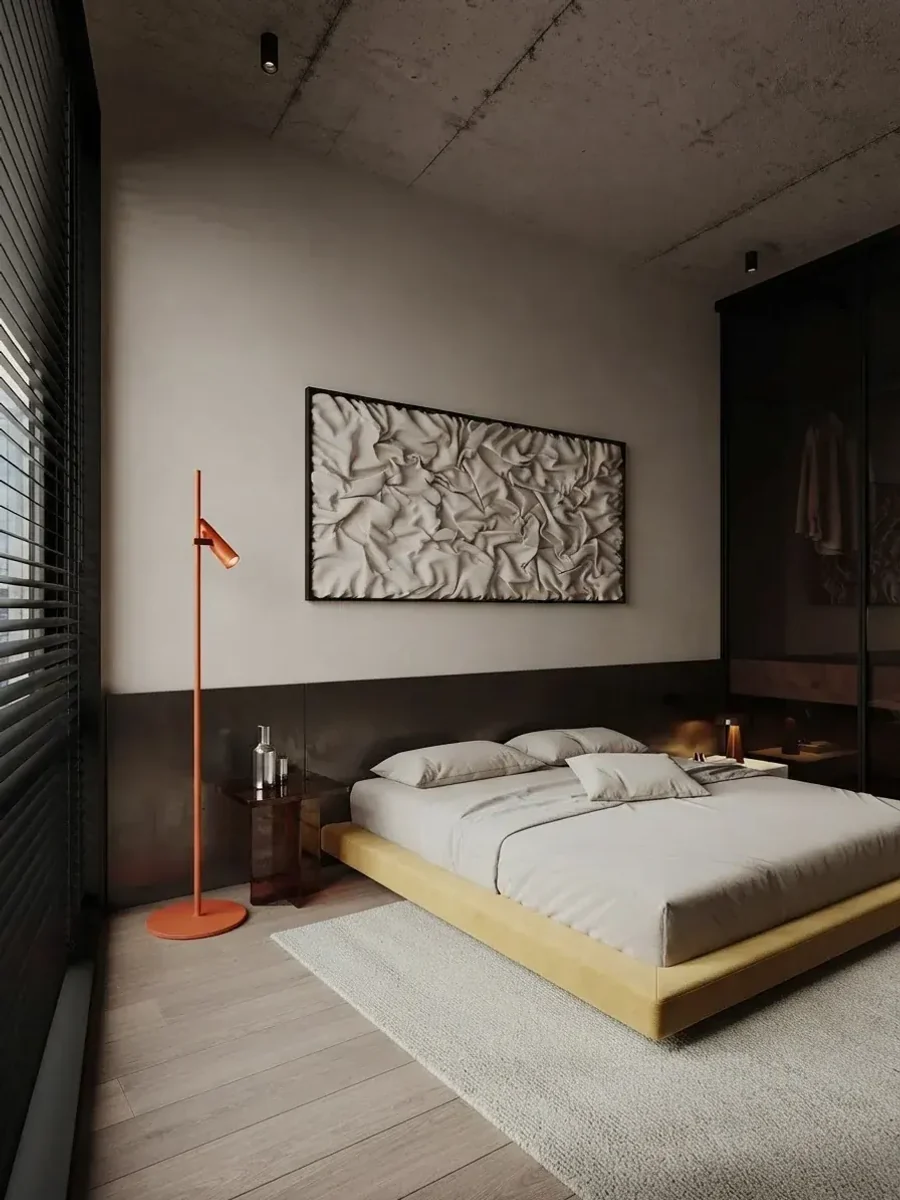 Loft bedroom with a concrete ceiling, a low mustard platform bed and one wide sculptural relief canvas in a thin black frame centred above the bed at about two thirds of its width