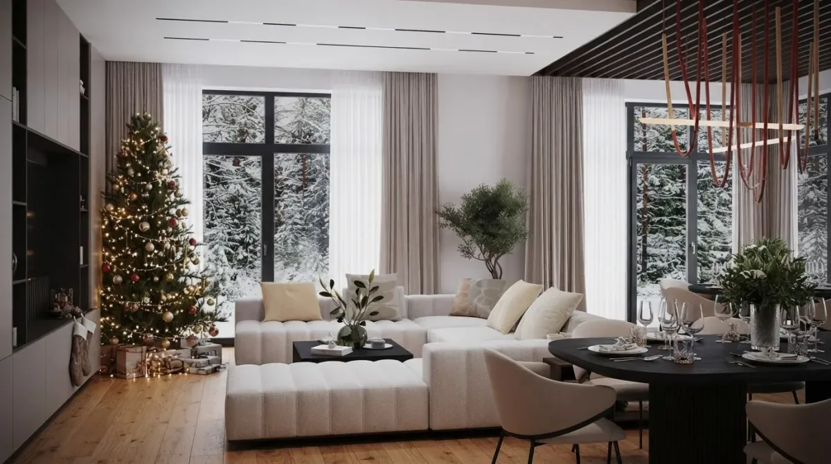 Bright chalet living room seen from the dining end with a Christmas tree beside the glass wall on the left, a white sectional sofa, a black dining table with cream chairs and a dark fireplace wall on the right