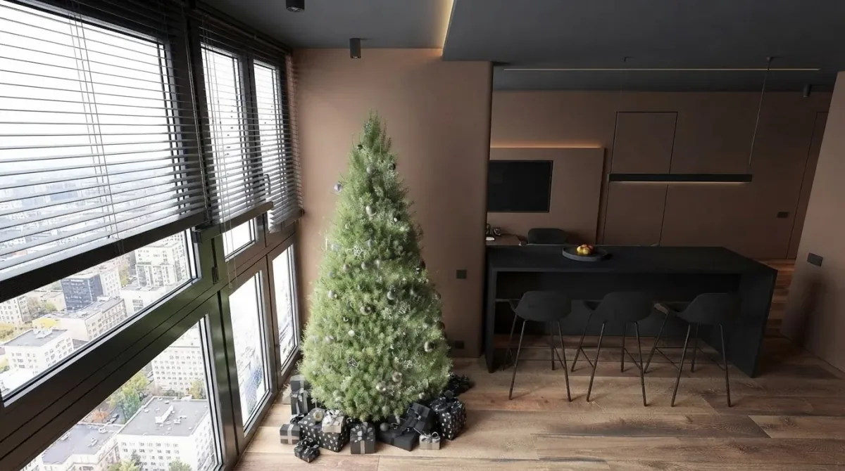 Small dark loft living space with a simply lit green fir tree standing in the corner beside a wall of windows with the city below, black wrapped gifts underneath and a black kitchen island with bar stools behind
