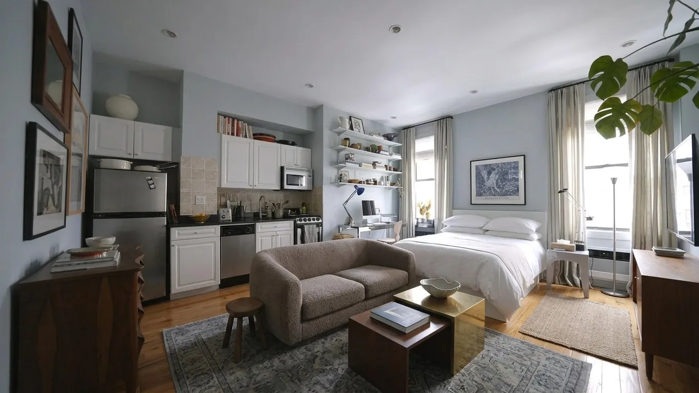 Studio apartment with earthy warm tones, wooden furniture, plants, vintage rug, and layered textures