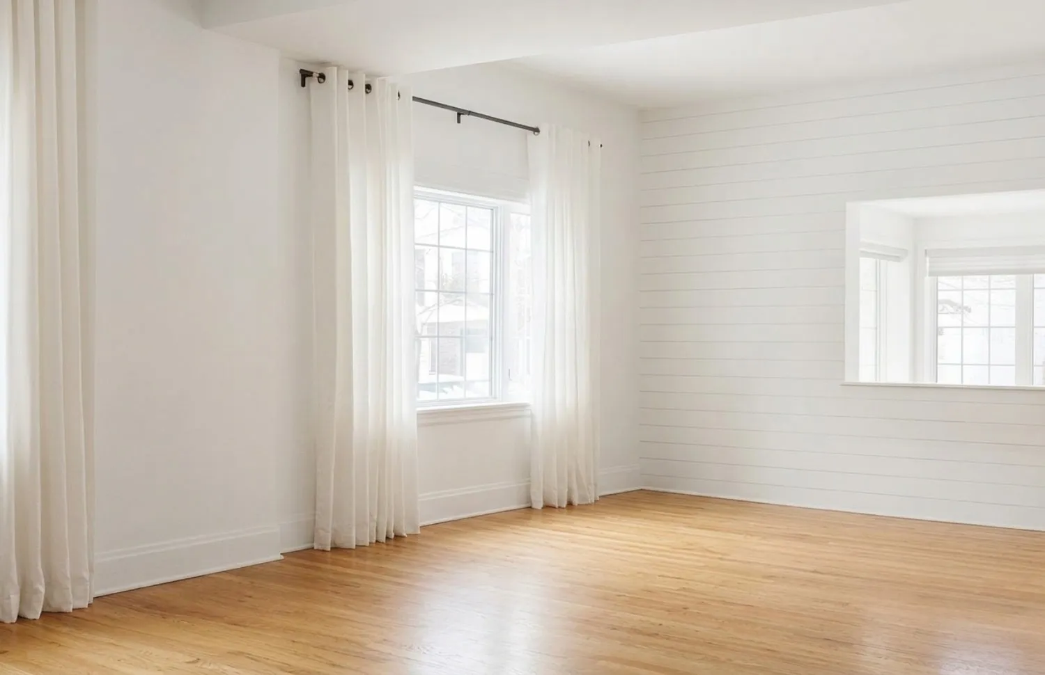 Same room after AI furniture removal showing empty room with shiplap walls, hardwood floors, and windows preserved perfectly
