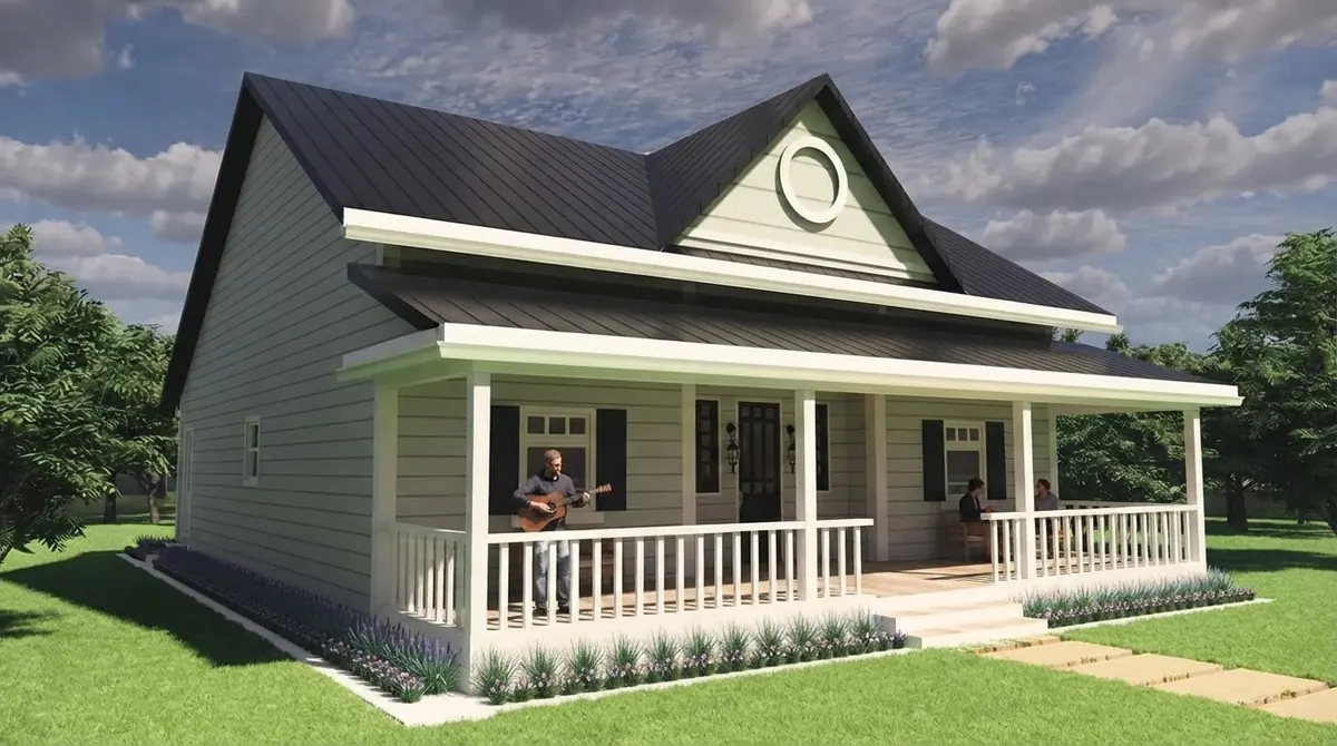 Sage green lap sided cottage with a white full width front porch, white railings, black shutters and a dark shingle roof on an open lawn