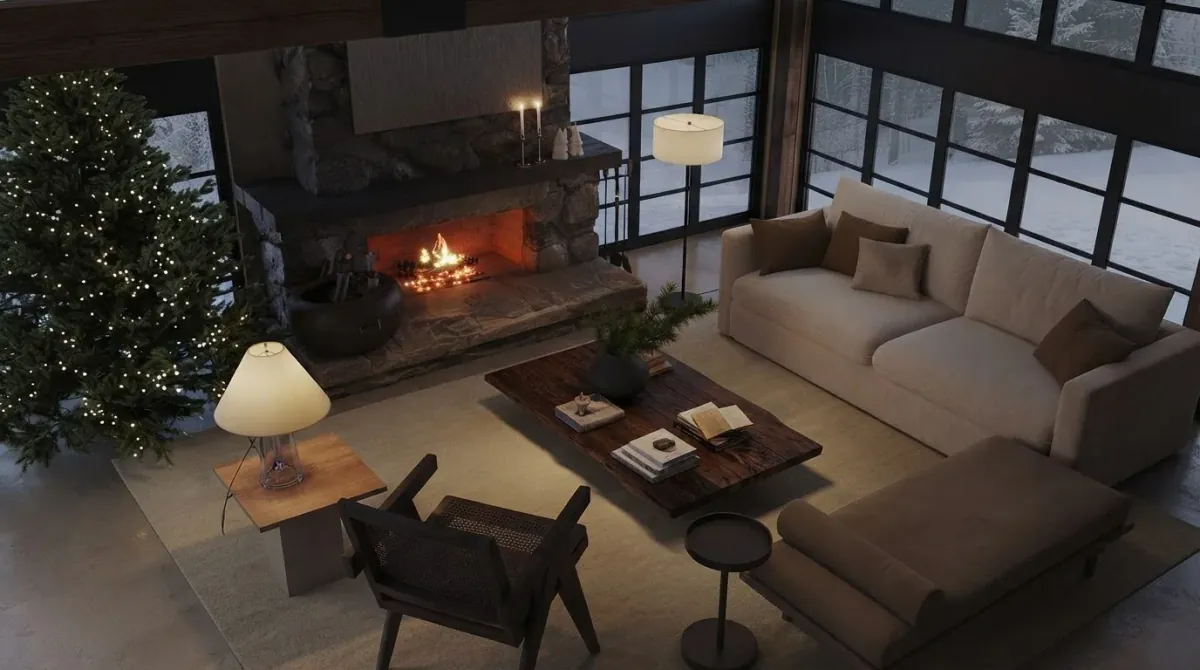 Chalet living room seen from above with a lit fir tree in the far left corner, a stone fireplace with a fire in the middle of the wall and the cream sofa and leather daybed between them