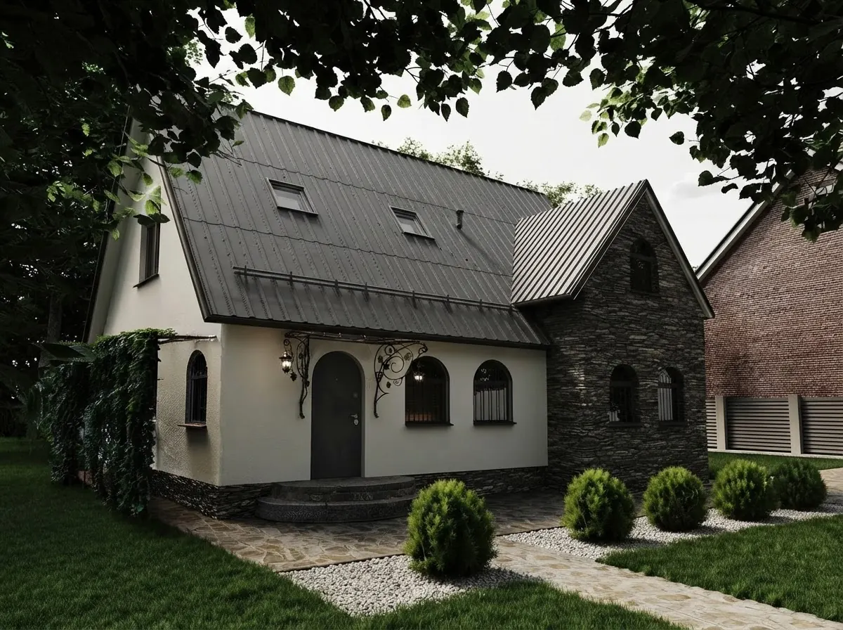 Cream rendered cottage with a dark fieldstone gable, a charcoal metal roof with skylights and arched windows behind clipped boxwoods