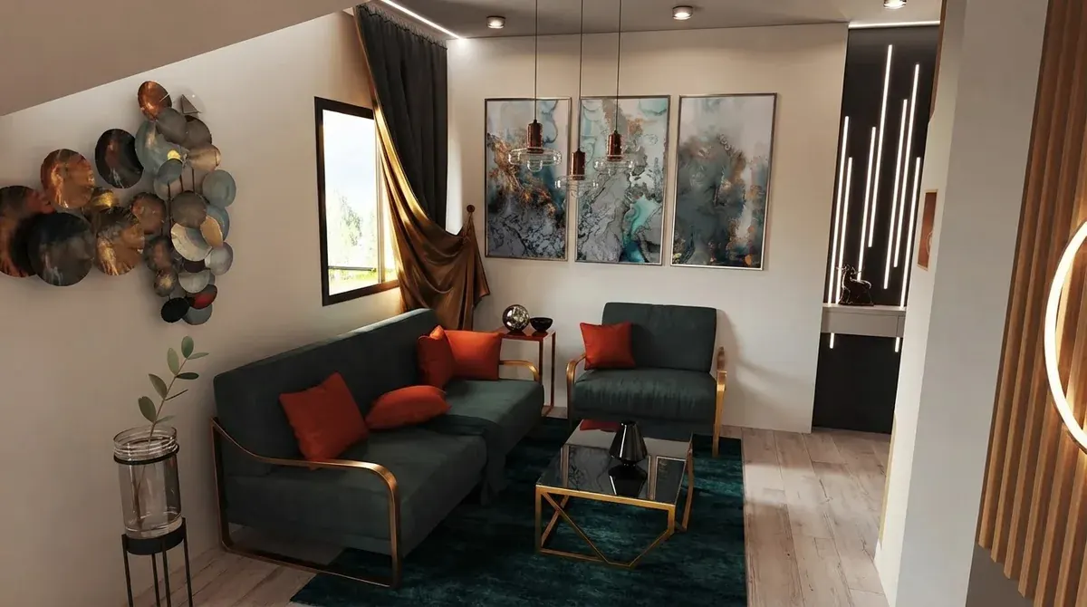 Living room with a dark teal velvet sofa and armchair with red cushions, a gold framed glass coffee table, a teal rug and three turquoise abstract artworks on the wall