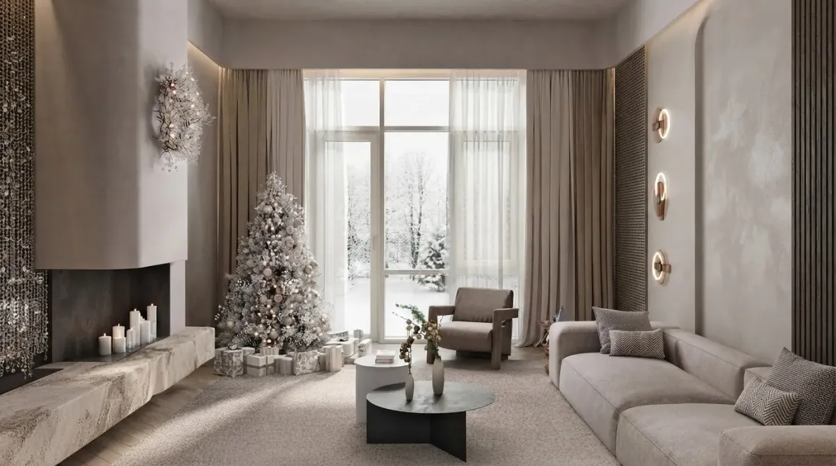 White minimal living room with a floating stone hearth and candles, a flocked white Christmas tree beside tall windows onto a snowy garden, a dried wreath on the chimney breast and a grey sofa